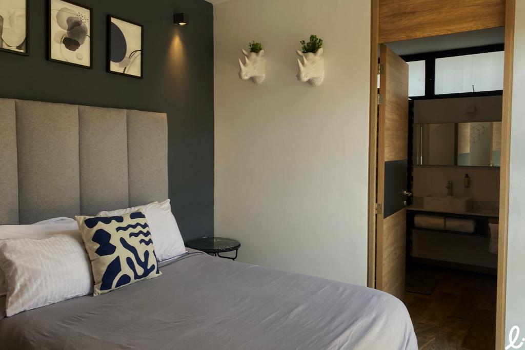 a bedroom with a bed and two plants on the wall at Lapso At Alarcón in Guadalajara