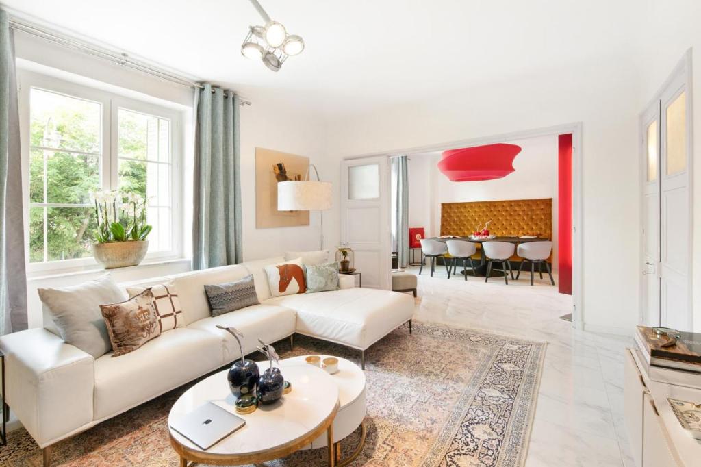 un salon avec un canapé blanc et une table dans l'établissement Palais Alexandre, à Cannes