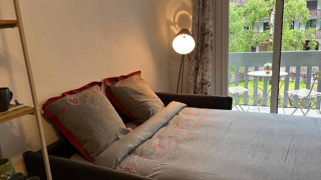 een bed in een kamer met een bank en een raam bij STUDIO DENT DU CROCODILE, AIGUILLE du MIDI, BALCON, PARKING in Chamonix-Mont-Blanc