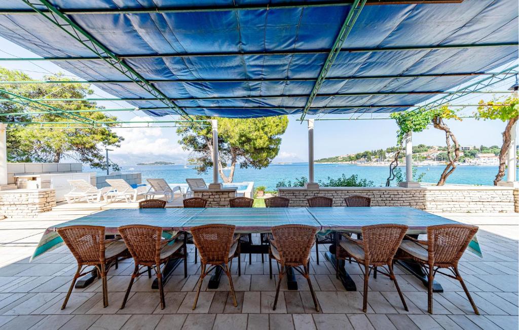 stół i krzesła na tarasie z widokiem na ocean w obiekcie Apartment Koludrt Bb Croatia w mieście Lumbarda