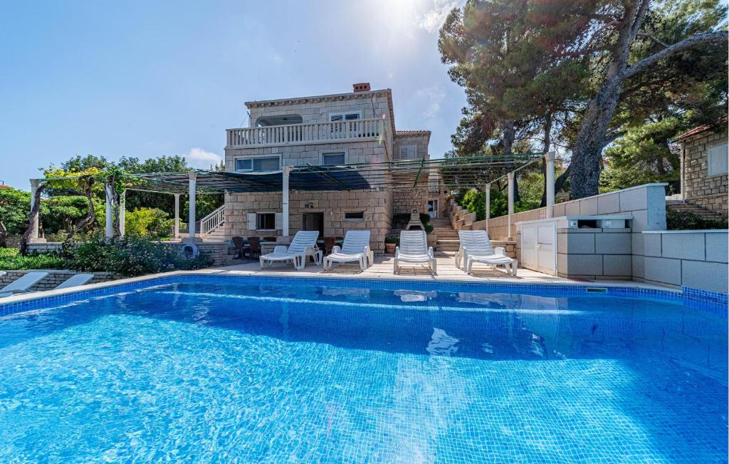 basen z krzesłami i domkiem w obiekcie Apartment Koludrt Bb Croatia w mieście Lumbarda