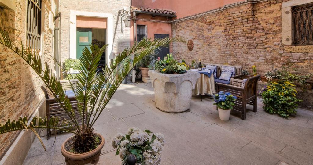 um pátio com uma mesa, cadeiras e plantas em Ca' della Corte em Veneza