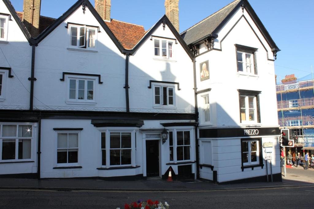 a white building on the side of a street at The George Hotel Stansted Airport in Bishops Stortford