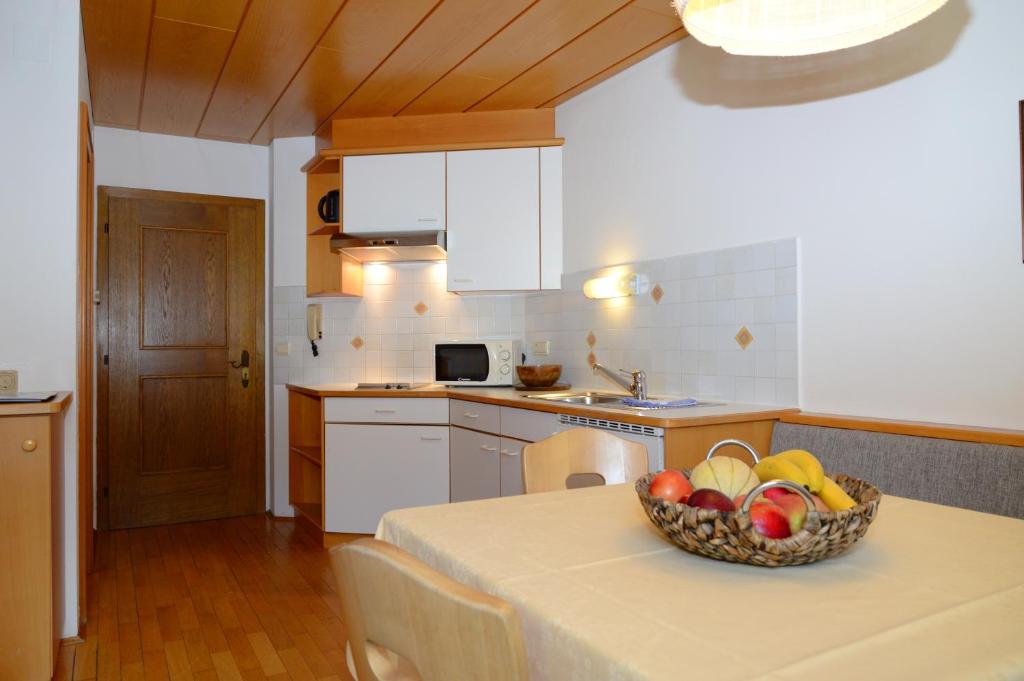 a kitchen with a table with a bowl of fruit on it at Residence Granvara in Ortisei