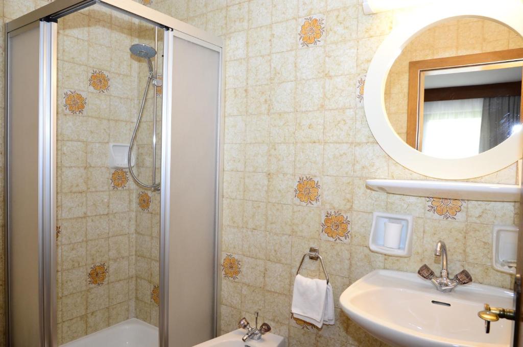 a bathroom with a shower and a sink and a mirror at Residence Granvara in Ortisei