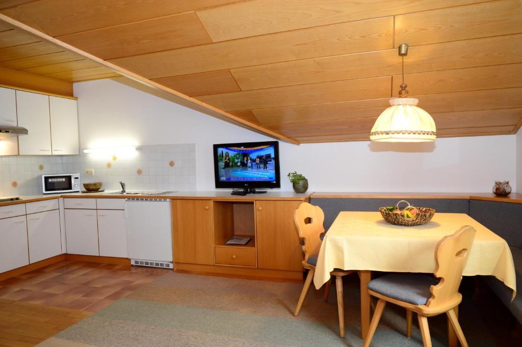 a kitchen with a table and a television and a table and chairs at Residence Granvara in Ortisei