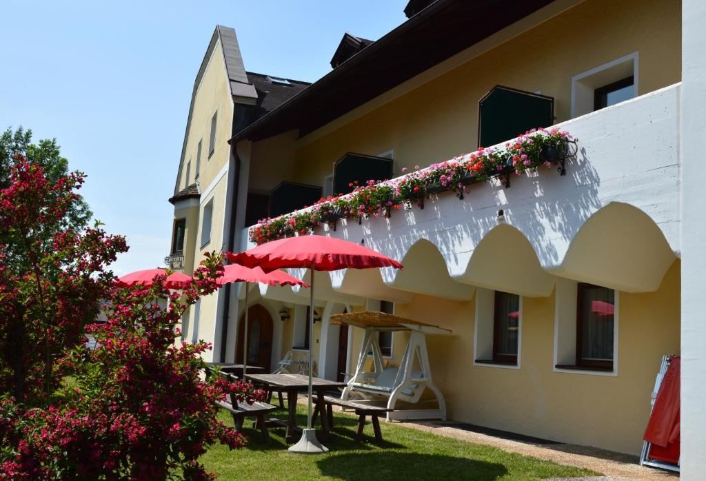 a building with tables and umbrellas in a yard at Residence Granvara in Ortisei