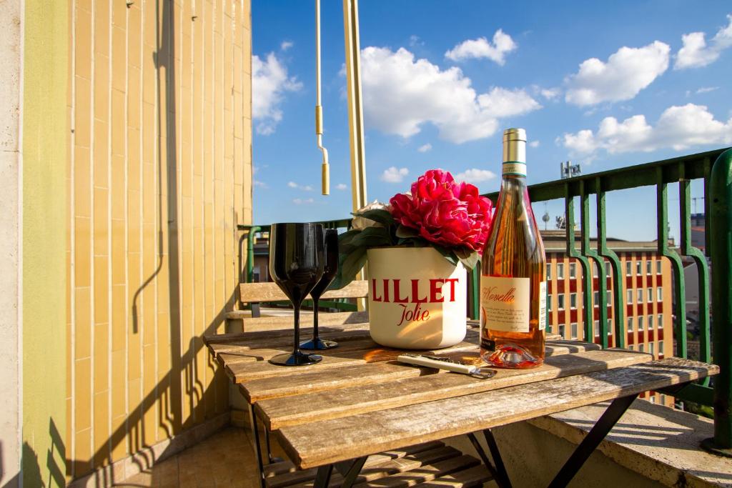 a bottle of wine and a glass on a table on a balcony at Moderno Appartamento Navigli Milano:Two Nice Jacks in Milan