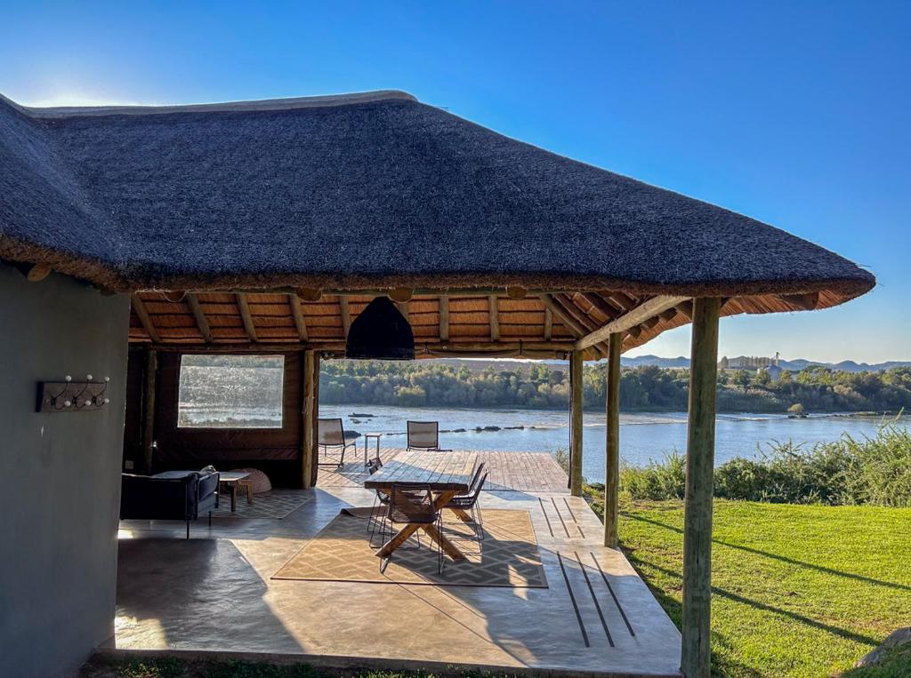a large pavilion with a table and a table at Tzamenkomst River Lodge in Colesberg
