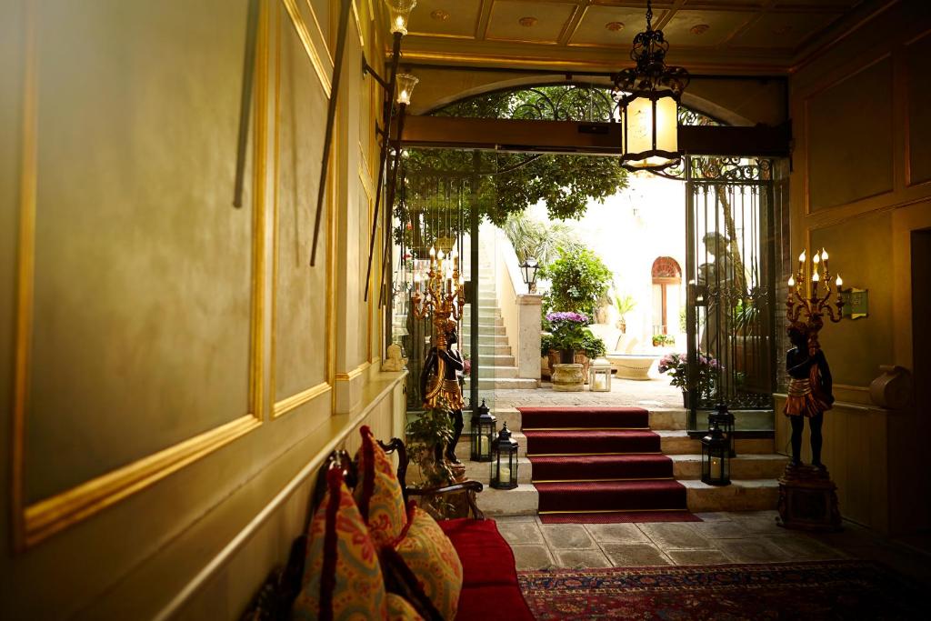 ヴェネツィアにあるPalazzo Paruta & Wellness Suitesの赤いカーペットの階段が敷かれた廊下