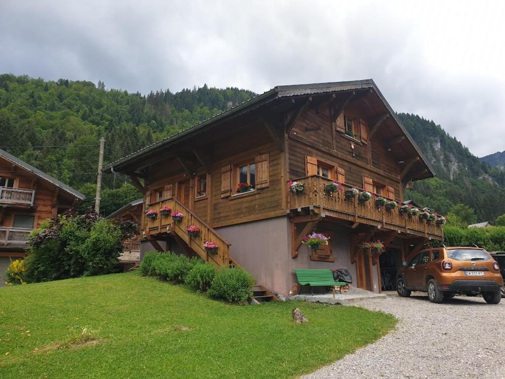 a wooden house with a car parked in front of it at Chalet spacieux avec garage privé, animaux acceptés, terrasse et jardin, idéal pour familles ! - FR-1-692-101 in Abondance