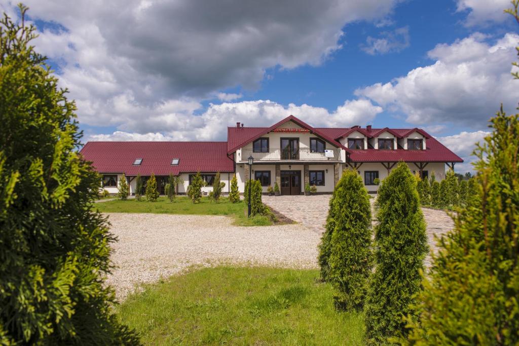 a large house with a red roof and a yard at Folwark Księżnej Anny in Siemiatycze