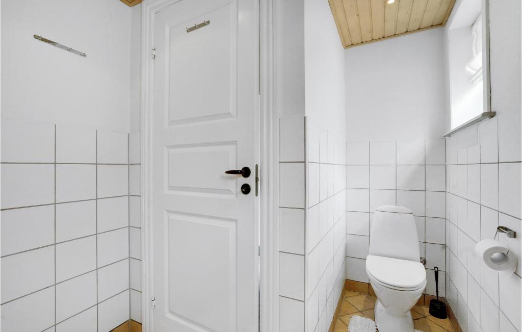 a white bathroom with a toilet and a window at Nice Home In Tnder With Wifi in Tønder