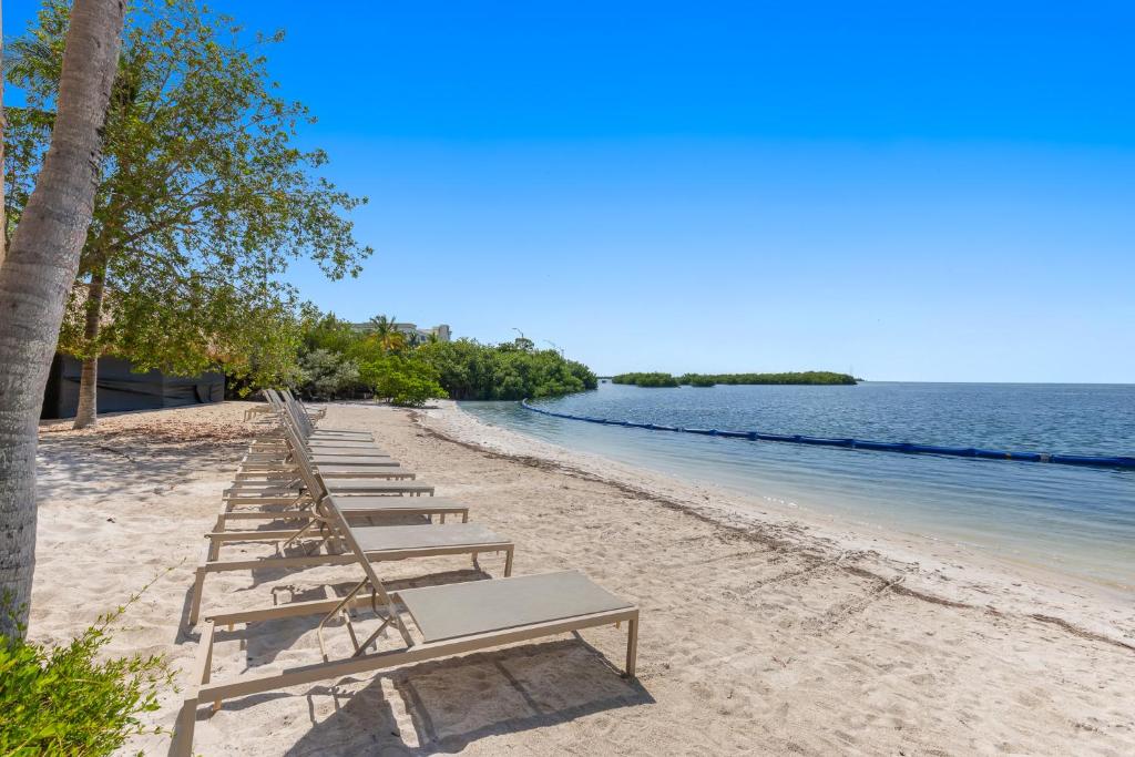 eine Reihe von Liegestühlen am Strand in der Unterkunft Beachside Resort &amp; Residences in Key West