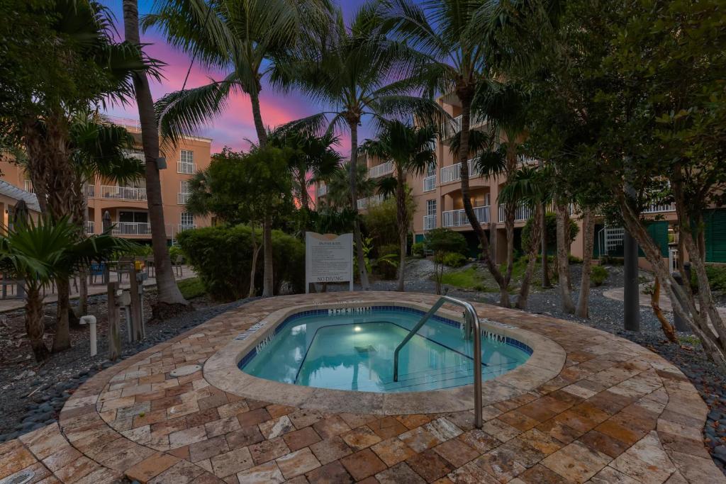 ein Pool mit einem Resortgebäude im Hintergrund in der Unterkunft Beachside Resort &amp; Residences in Key West