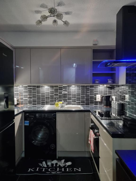 a kitchen with a washing machine in the middle at Stylish London Apartment & Free Parking in London