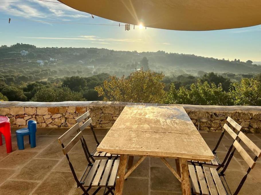 a wooden table and two chairs sitting on a patio at Trullo dell'Upupa in Ostuni