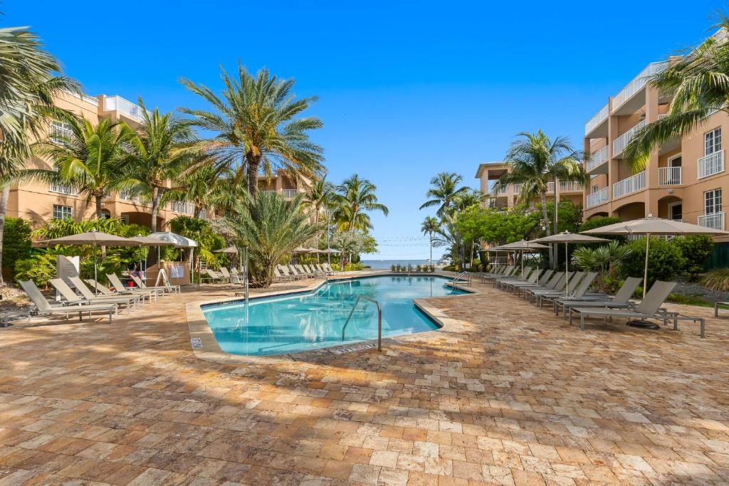 einen Pool im Resort mit Stühlen und Sonnenschirmen in der Unterkunft Beachside Resort &amp; Residences in Key West