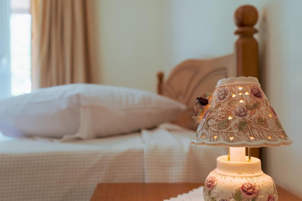a lamp sitting on a table next to a bed at Home Sweet Home A Quiet,Spacious Two-Bedroom house in Dërmish