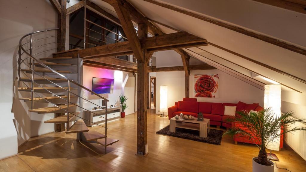 a spiral staircase in a living room with a red couch at Amazing Charles Bridge Apartment in Prague