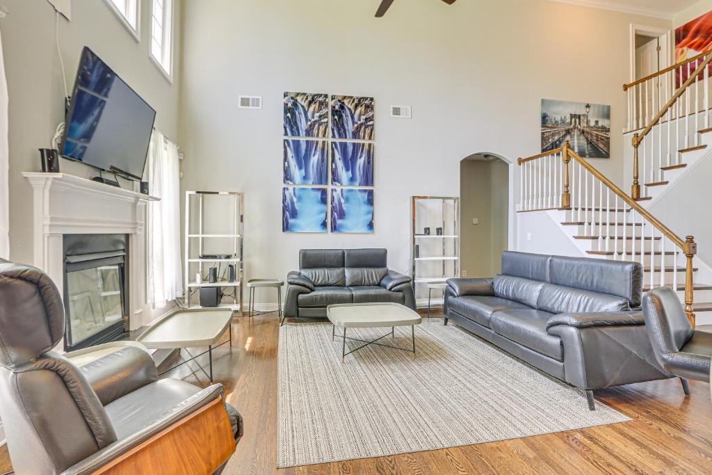 a living room with leather furniture and a fireplace at Spacious High Point Family Home with Yard and Grill in High Point