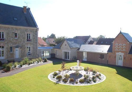 une grande cour avec une fontaine en face d'une maison dans l'établissement Logis Hotel Chemin Des Dames Le Relais De Fleurette, à Pontavert