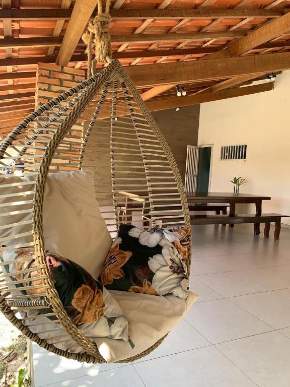 a hanging hammock chair with pillows in a room at Amaro Residence in Santo Amaro
