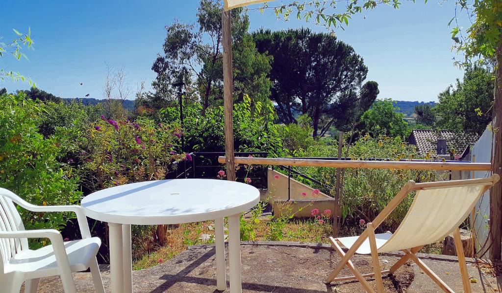 une table et des chaises sur une terrasse avec vue dans l'établissement Au calme, aux portes de Montpellier, à Grabels