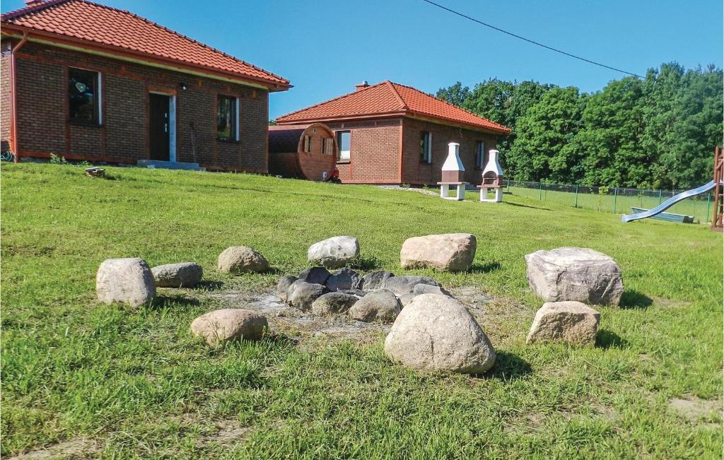 a group of rocks in a field next to a house at 2 Bedroom Lovely Home In Glowczyce in Główczyce