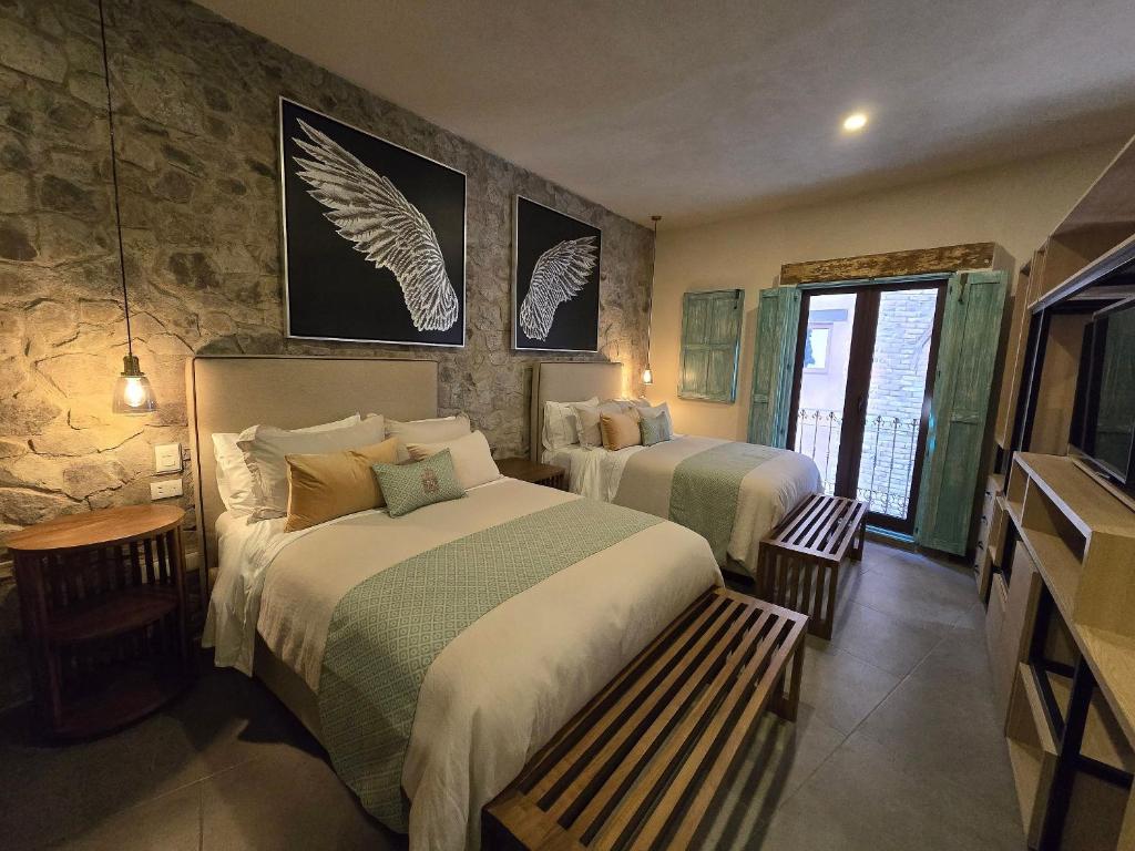 a bedroom with two beds and a stone wall at Castello di Carlo - Loft Carlo II in Santeagueda
