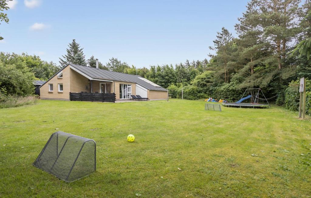 a yard with a house and a ball on the grass at Cozy Home In Spøttrup With Sauna in Spottrup