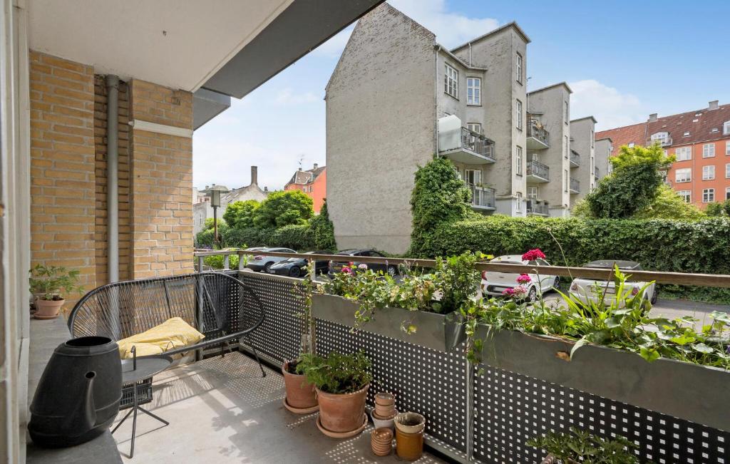 a balcony with potted plants and buildings at Nice Apartment In Frederiksberg C in Copenhagen