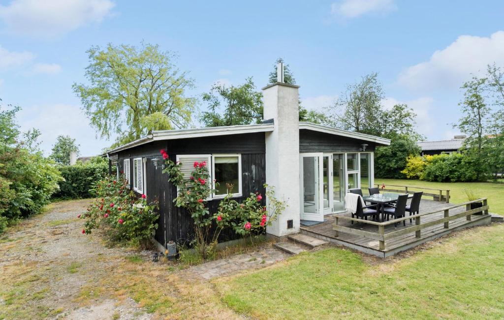 un piccolo cottage nero con tavolo e sedie di 3 Bedroom Cozy Home In Juelsminde a Sønderby