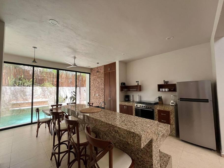 cocina con encimera, nevera y mesa en Jungle Retreat Luxury Villa with Pool inTulum, en Tulum