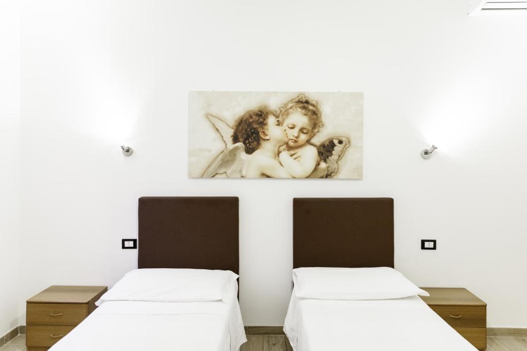 ボローニャにあるIN FIERA 8 Apartment superiorの壁に絵が描かれた部屋のベッド2台