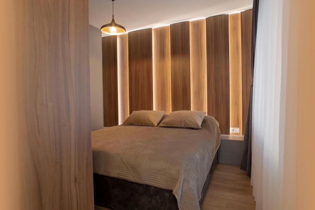 a small bedroom with a bed with a window at Lux Apartments in Pristina