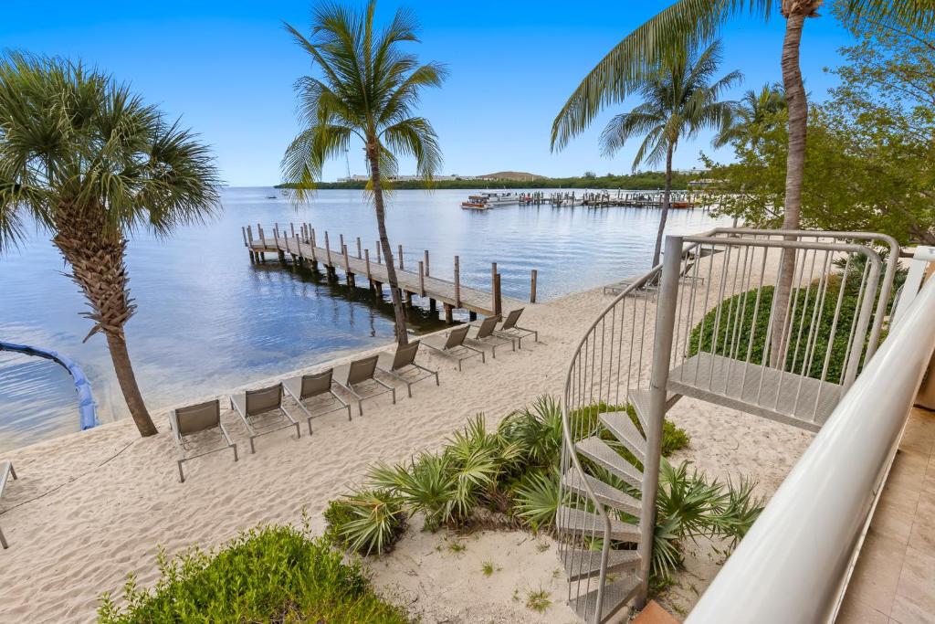 eine Rutsche am Strand mit Stühlen und einem Dock in der Unterkunft Beachside Resort &amp; Residences in Key West
