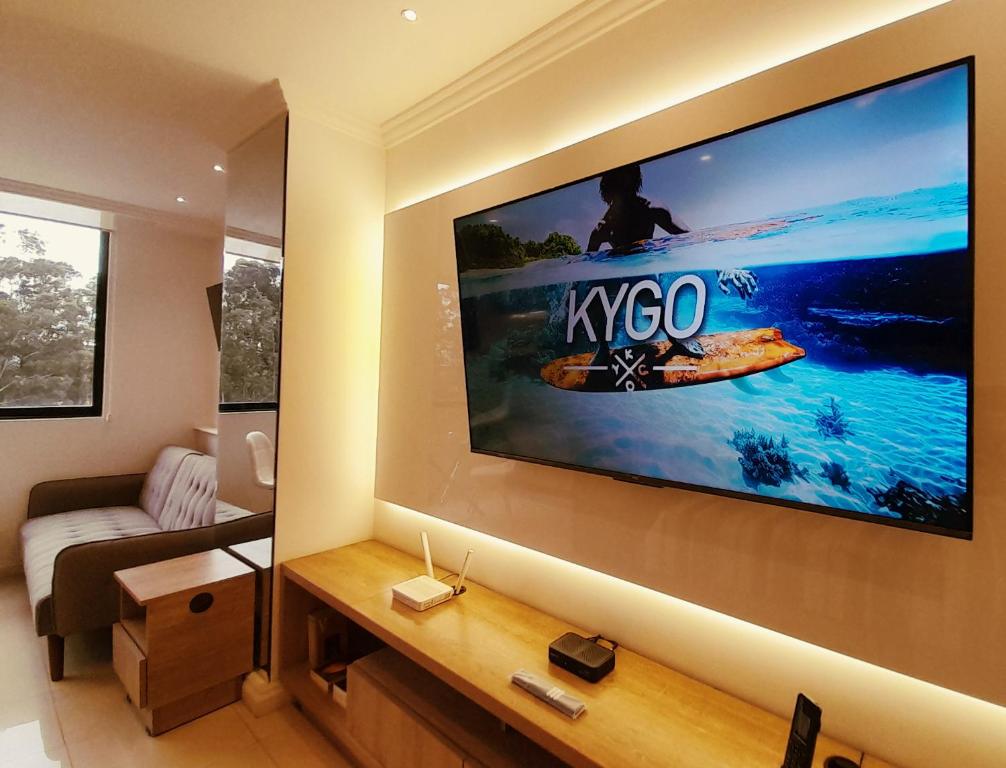 クエンカにあるElegante Suite Privada en Cuenca - Parqueo Incluidoのリビングルーム(壁に大型テレビ付)