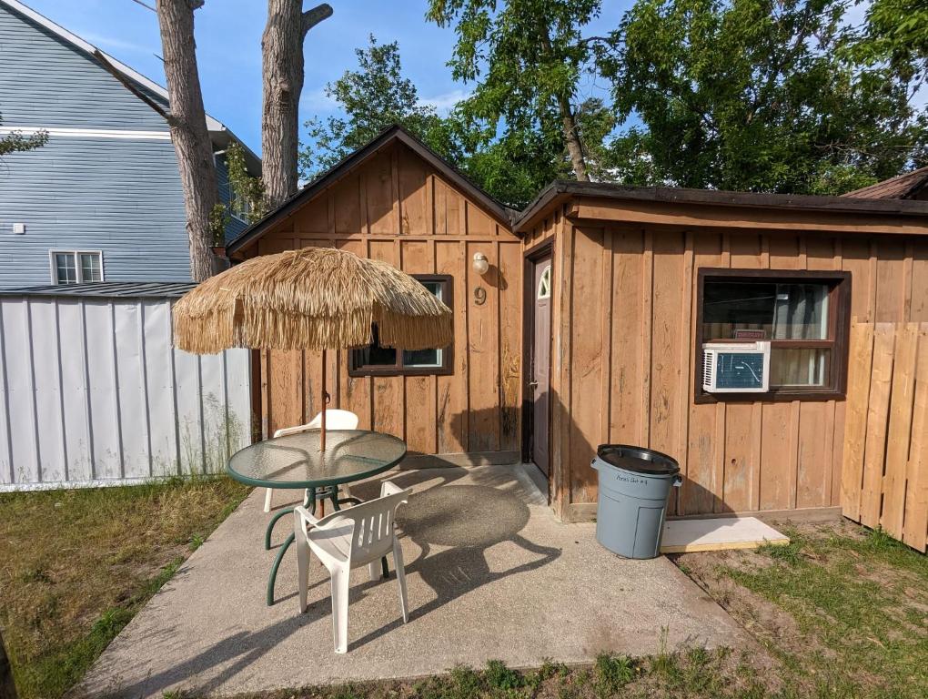 un patio con tavolo e sedie e un edificio di Tiny Wood Cottage 09 a Wasaga Beach