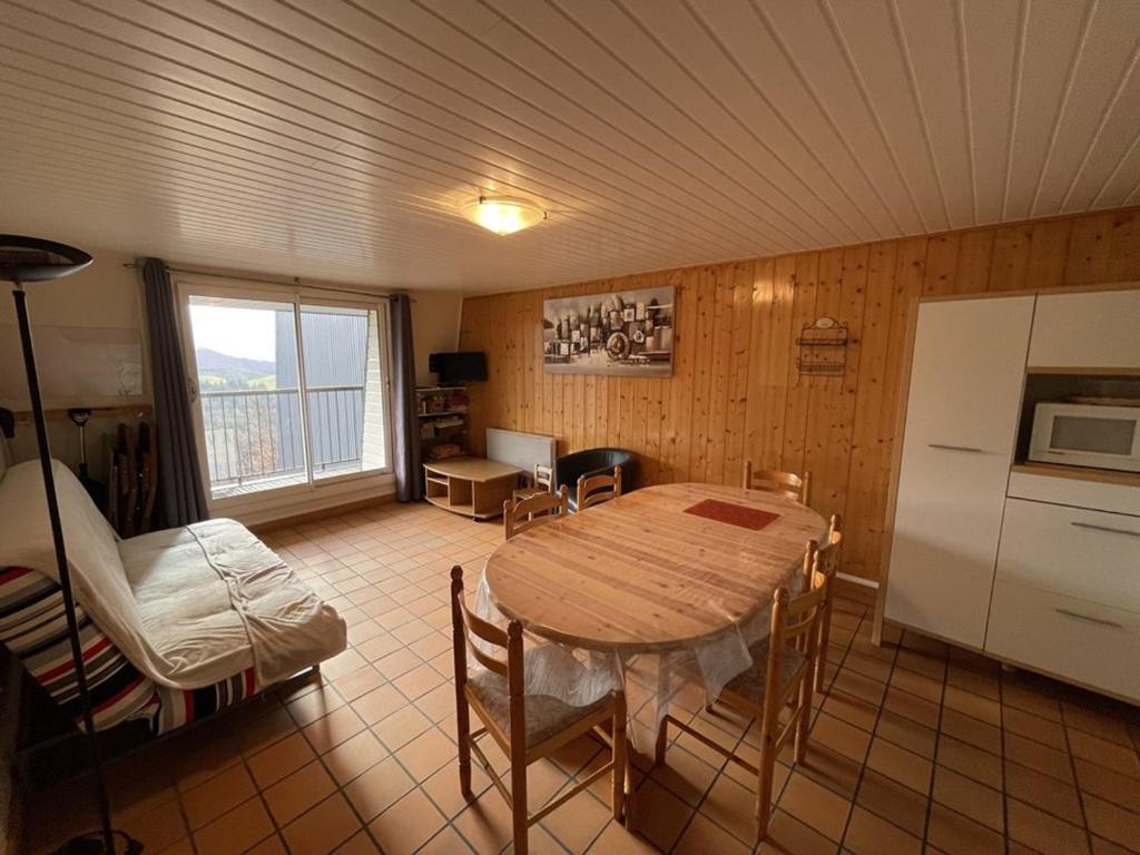 a kitchen and dining room with a table and a refrigerator at Appartement 2 chambres proche pistes avec balcon et parking gratuit - FR-1-787-14 in Saint-Jacques-des-Blats