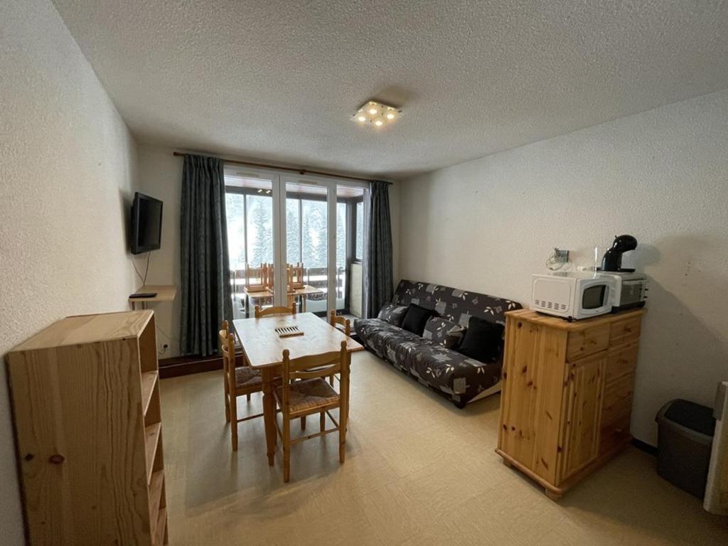 un salon avec un canapé et une table dans l'établissement Appartement T2 cabine avec balcon, face aux pistes, exposé sud, commerces à proximité - FR-1-787-29, à Laveissière