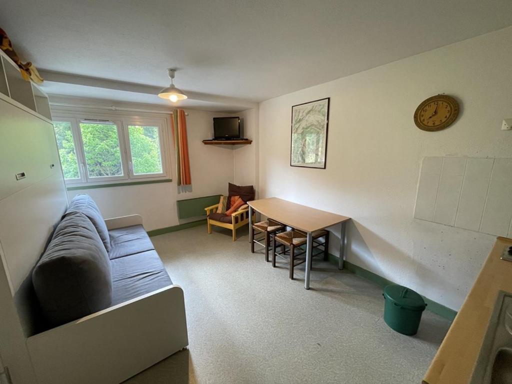 un salon avec un canapé et une table dans l'établissement Studio cosy à Laveissière près des pistes, 2 lits superposés et lit rabattable, parfait pour l'hiver - FR-1-787-8, à Laveissière