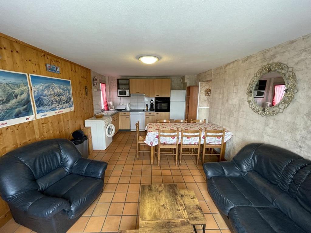 a living room with a table and chairs and a kitchen at Appartement spacieux avec animaux admis et parking gratuit - FR-1-787-18 in Saint-Jacques-des-Blats