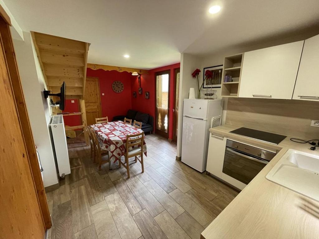 a kitchen with a table and a kitchen with white appliances at Duplex rénové 2 chambres, proche pistes, navette et gare, avec wifi et équipements complets - FR-1-787-4 in Laveissière