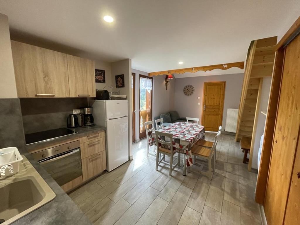 une cuisine avec une table et une salle à manger dans l'établissement Chalet cosy 50m² avec WiFi à 300m des pistes, 2 chambres, casier à skis, proche gare et navette - FR-1-787-12, à Laveissière