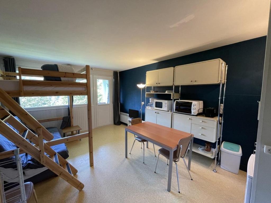 Zimmer mit einem Tisch und einem Etagenbett in der Unterkunft Appartement cosy avec balcon, accès direct piste et parking privatif - FR-1-787-20 in Laveissière