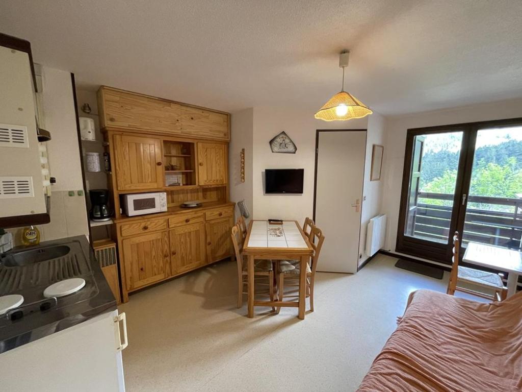 Cette chambre comprend une cuisine et une table avec table. dans l'établissement T2 cabine avec balcon, près des pistes - FR-1-787-21, à Laveissière
