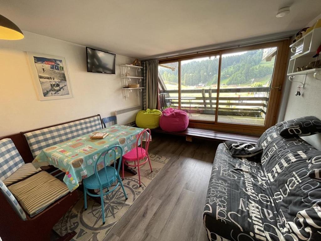 un salon avec une table et un canapé dans l'établissement Studio confortable avec balcon plein sud, à côté des pistes et commerces - FR-1-787-23, à Laveissière