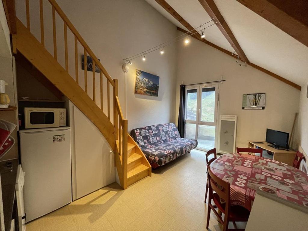 - un salon avec un escalier, un canapé et une table dans l'établissement Studio cosy face aux pistes avec mezzanine et navette gratuite - FR-1-787-39, à Laveissière
