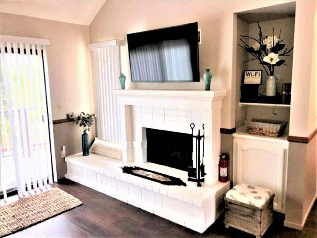 Una sala de estar con chimenea y un televisor encima. en Village Condo condo, en Lake Arrowhead